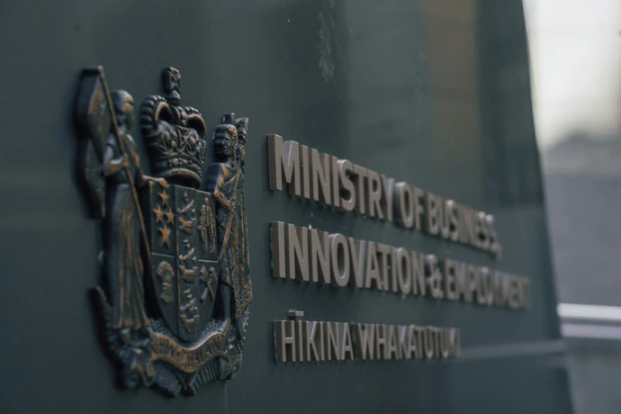 A bronze coat of arms and the Ministry of Business, Innovation and Employment sign